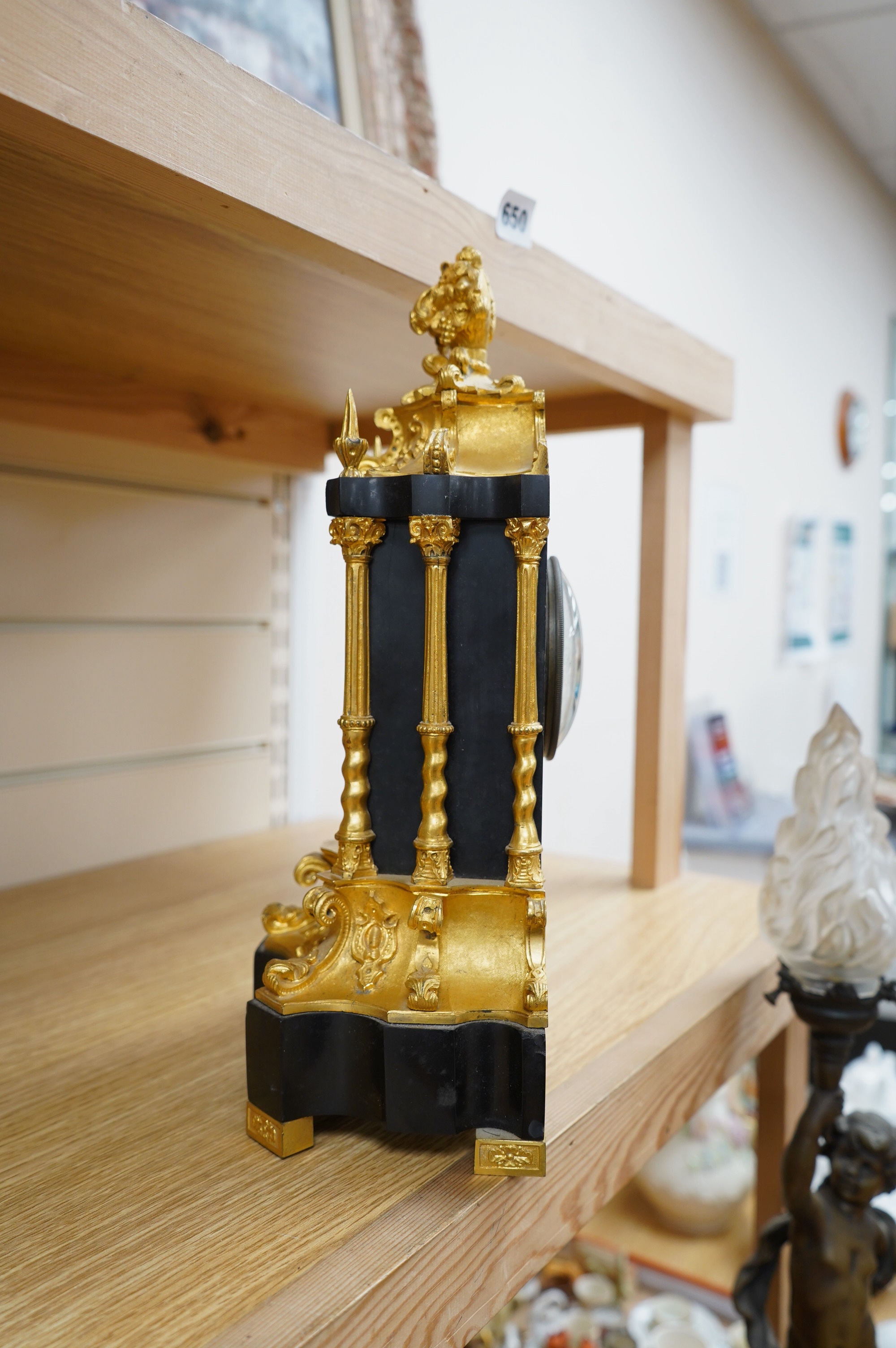 A French ormolu and slate mantle clock with a silk suspension movement, 33cm high. Condition - fair, cracks to the enamel dial.